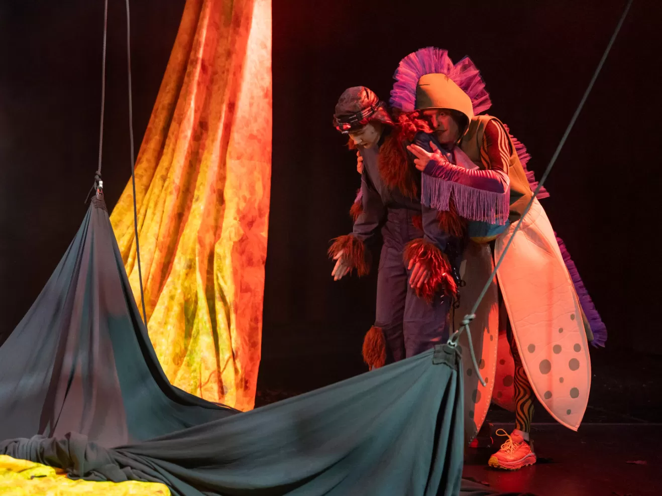 Zwei Leute gucken traurig auf den Boden, auf dem große Tücher liegen