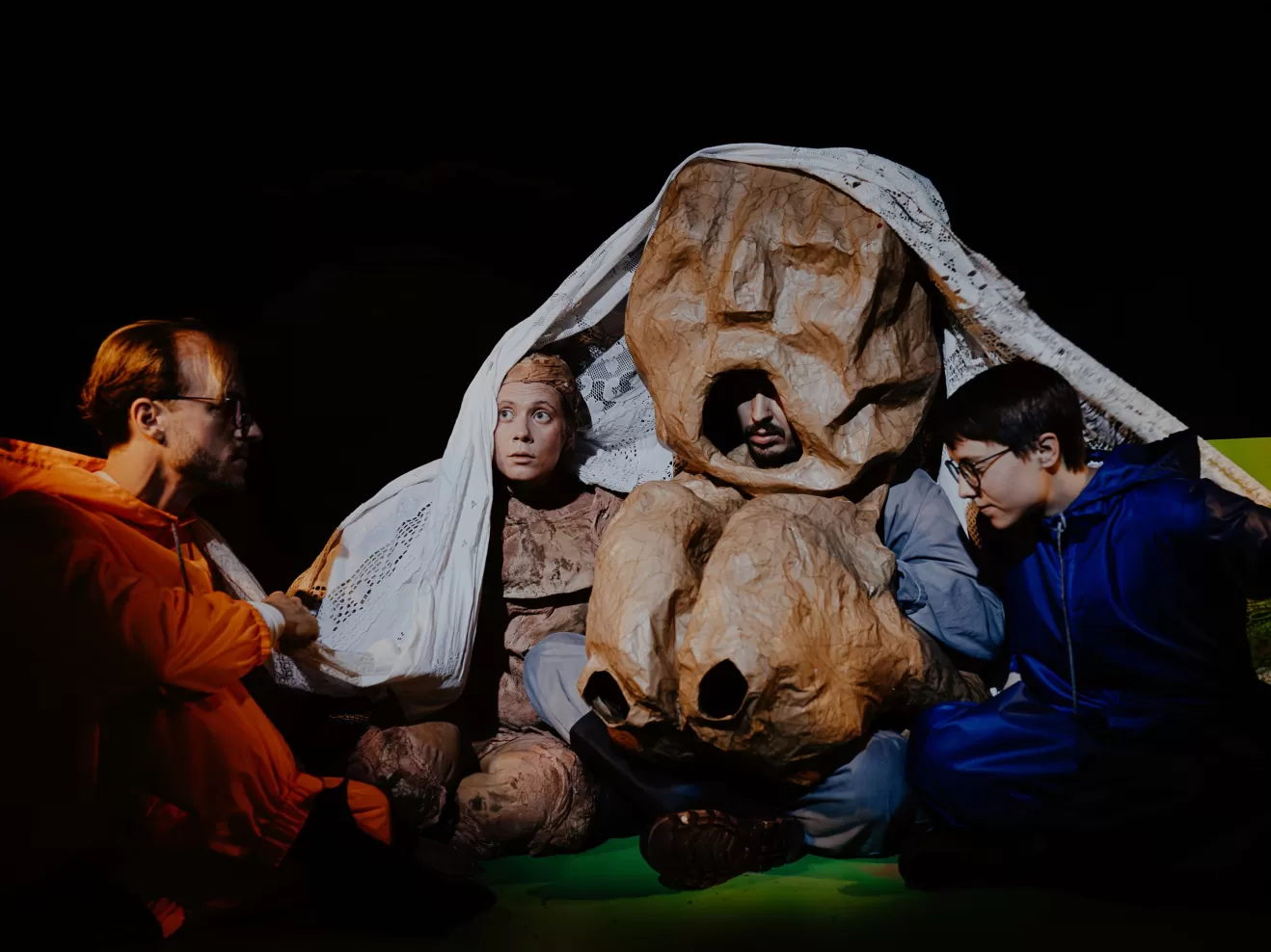 Mehrere Personen gemeinsam unter einer Decke.