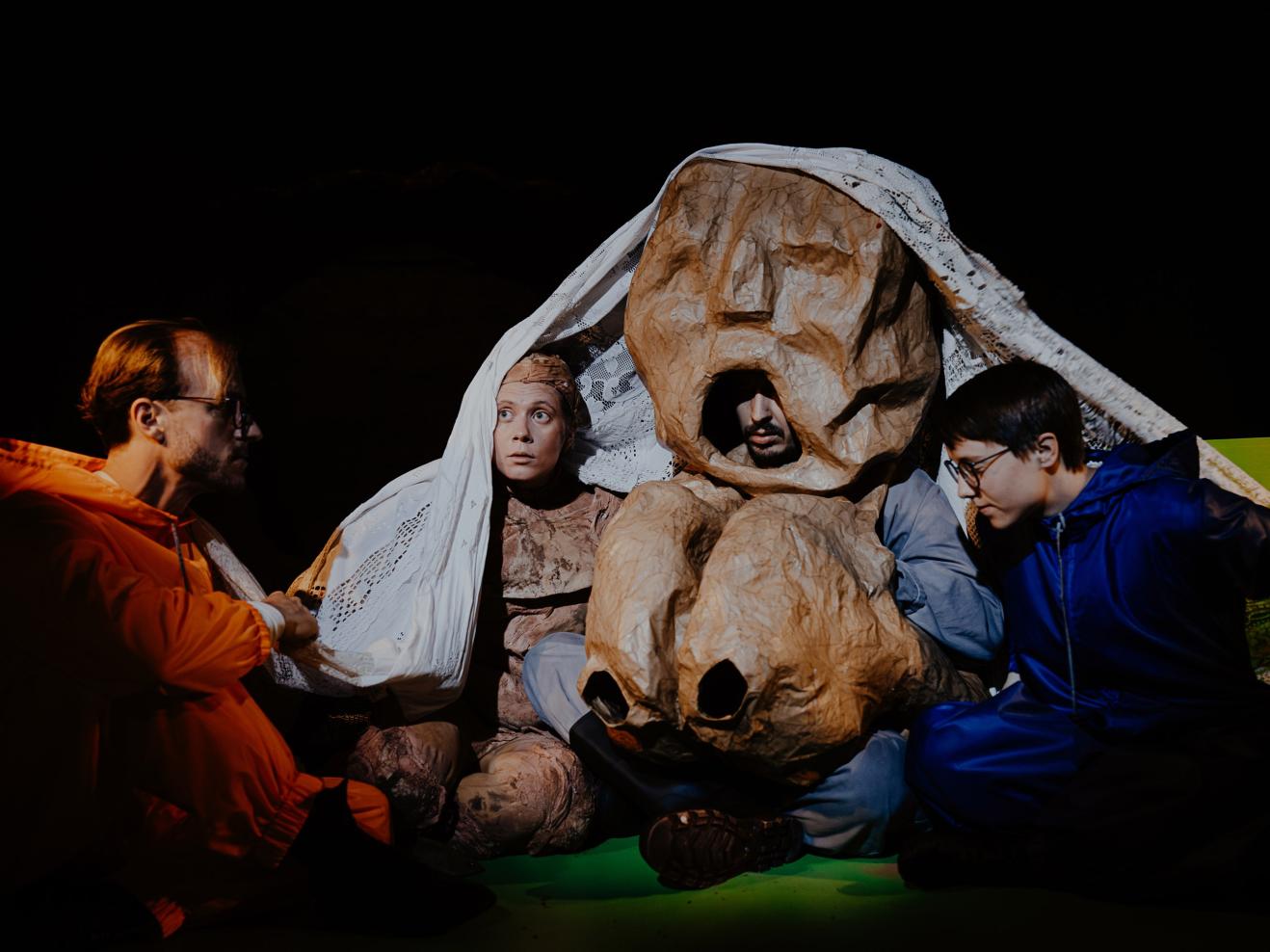 Mehrere Personen gemeinsam unter einer Decke.