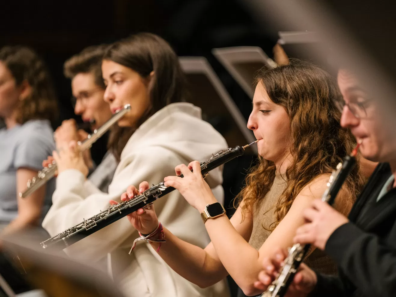 Foto aus einer Orchesterprobe, im Fokus stehen eine Flötistin und eine Oboistin