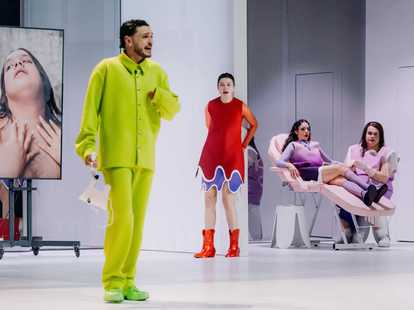 Zwei Menschen sitzen bei einem Kosmetikstuhl. Die beiden anderen stehen besorgt rum.