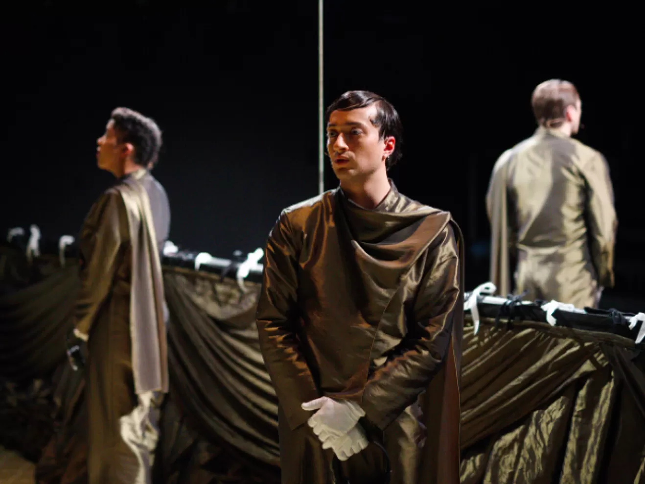 Drei Menschen tragen goldene Anzüge und pfeiffen