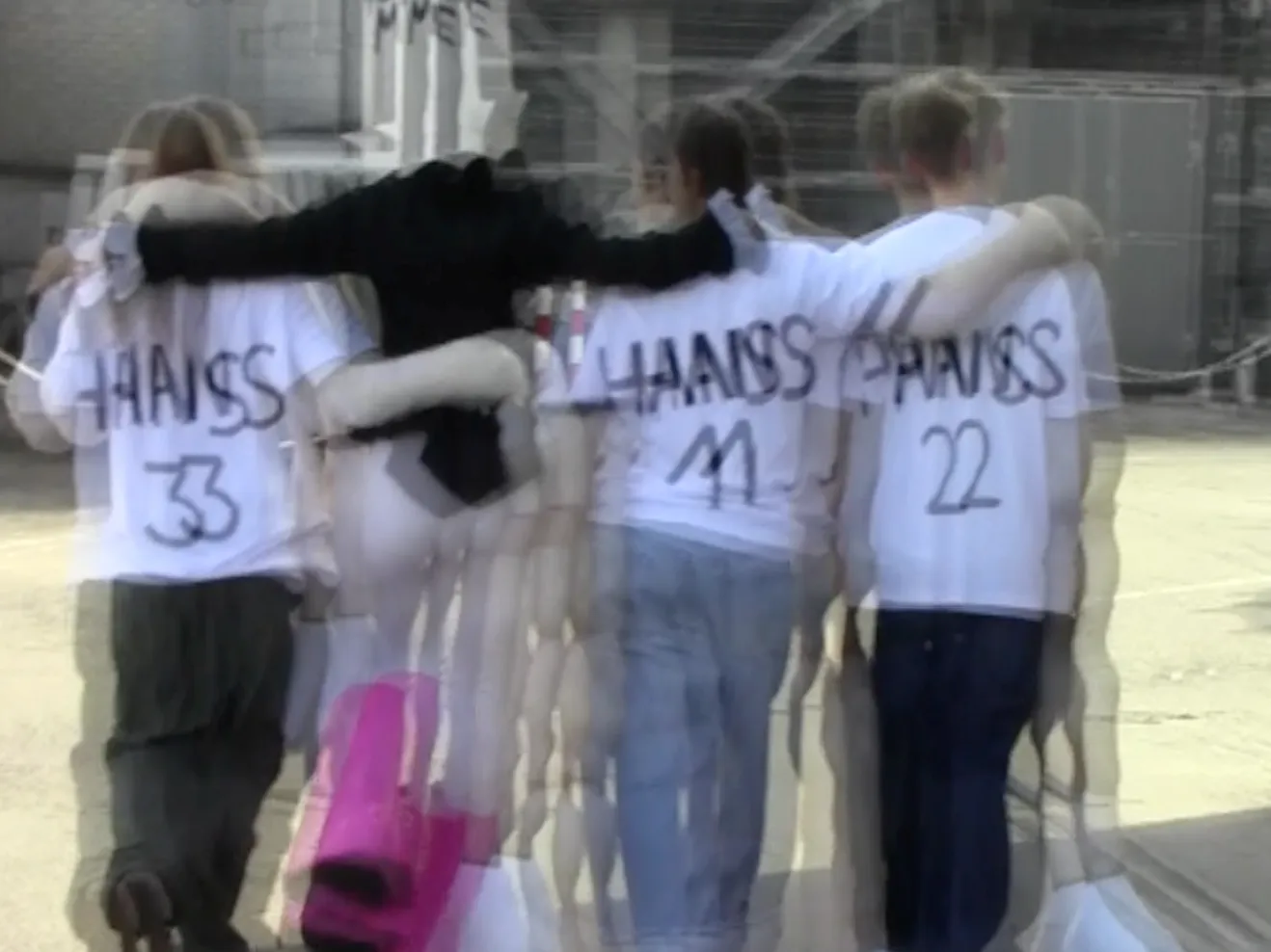 Ein verschwommenes Foto von vier Personen, auf deren Rücken "Hans" steht.