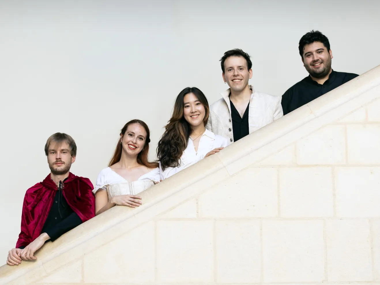 Die fünf Ensemblemitglieder des Ensembles Commedia dell'Arte stehen auf einer Treppe